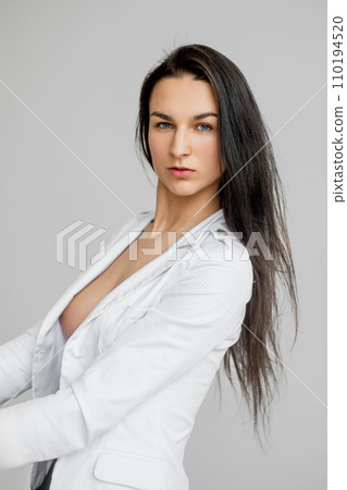 Studio portrait of strict woman in white jacket  110194520