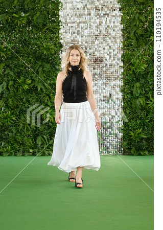 Middle-aged woman walking stylishly in fashion clothing. Middle-aged woman walking stylishly in fashion clothing. 110194535