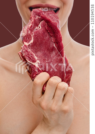 Teeth with dental braces bite raw beef meat 110194538
