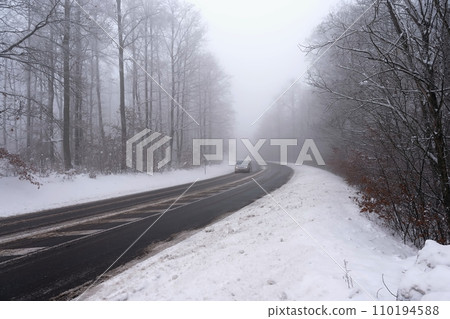 Cars in the fog. Bad winter weather and dangerous automobile traffic on the road. Light vehicles in foggy day. Cars in the fog. Bad winter weather and dangerous automobile traffic on the road. Light vehicles in foggy day. 110194588