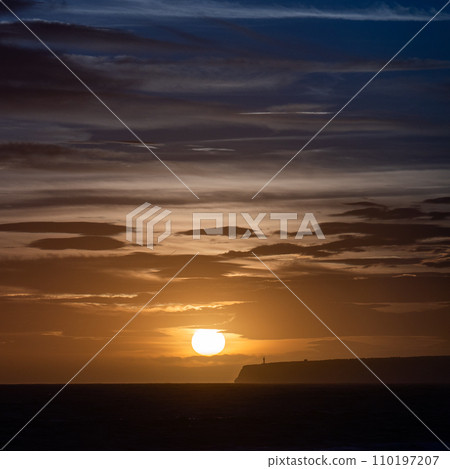 Lighthouse Silhouette on Cliff at Dusk with Calm Sea Background 110197207