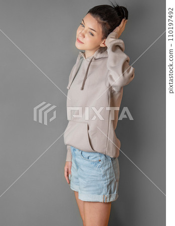 Pensive thoughtful young girl wearing sweatshirt with hood Pensive thoughtful young girl wearing sweatshirt with hood 110197492