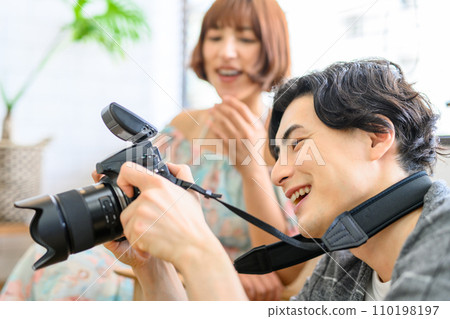 一位男攝影師向模特兒展示他的照片 110198197