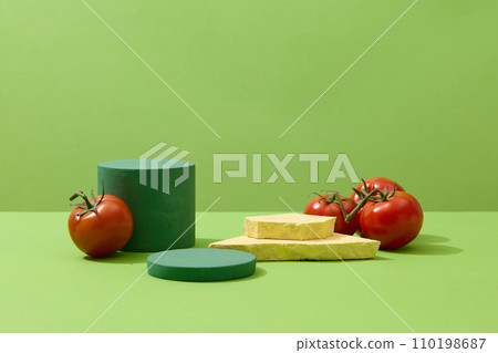 Geometric shaped podiums displayed with natural tomatoes. Green background. Tomatoes do an excellent job at keeping oil production in check  110198687