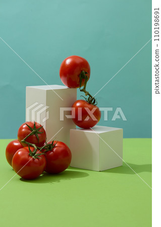 Green surface featured podiums in white color and fresh tomatoes. Eating tomatoes works from the inside out to give you added UV protection  110198691