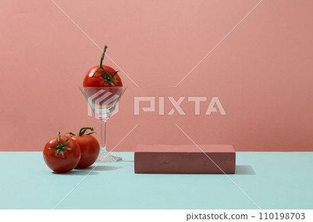 A cocktail glass containing a tomato, placed next to a rectangle podium. Concept scene stage showcase for new product, promotion sale, cosmetic presentation 110198703