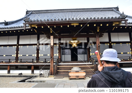 A man sightseeing at the beautifully decorated historical building of the National Treasure Kondo Hall of Ninna-ji Temple in Kyoto in spring in Japan A man sightseeing at the beautifully decorated historical building of the National Treasure Kondo Hall of Ninna-ji Temple in Kyoto in spring in Japan 110199175