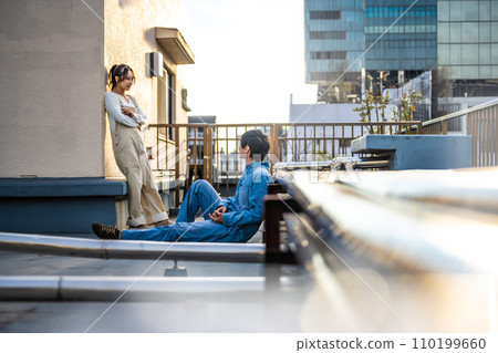 man and woman talking on the rooftop 110199660