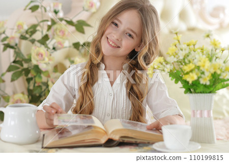 Close up portrait of young girl reading interesting big book Close up portrait of young girl reading interesting big book 110199815