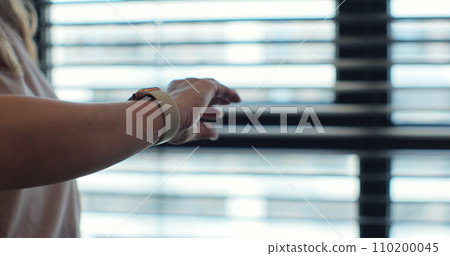 Woman fingers does double tap on smart watch for hands-free interaction. Woman using smartwatch wearable technology device. Woman fingers does double tap on smart watch for hands-free interaction. Woman using smartwatch wearable technology device. 110200045