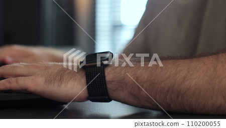 Freelancer man using smart watches. Browsing notifications and message. Smartwatch touching screen. Freelancer man using smart watches. Browsing notifications and message. Smartwatch touching screen. 110200055