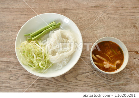rice noodles with spicy chicken curry sauce and fresh vegetable on plate rice noodles with spicy chicken curry sauce and fresh vegetable on plate 110200291