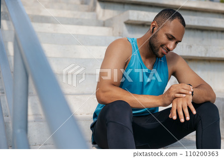 Young man in sportswear on the stairs after a good workout 110200363