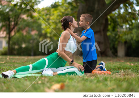 Woman in sportswear spending time in the park with her son Woman in sportswear spending time in the park with her son 110200845