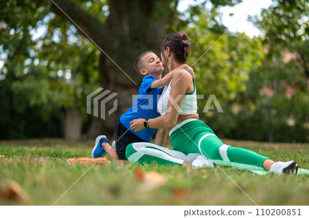 Woman in sportswear spending time in the park with her son 110200851