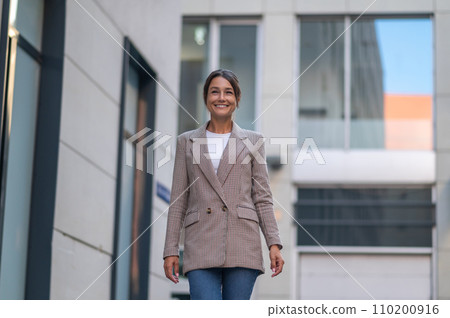 Beautiful business woman in suit near modern office building. Beautiful business woman in suit near modern office building. 110200916