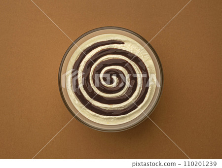 Bowl of sweet cream cheese with chocolate cream swirl on brown background with copy space, top view Bowl of sweet cream cheese with chocolate cream swirl on brown background with copy space, top view 110201239