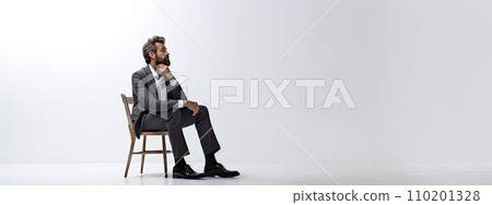 businessman in a suit sitting on chair 110201328