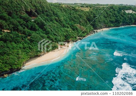 Paradise beach with blue tropical ocean and waves in Bali. Aerial view Paradise beach with blue tropical ocean and waves in Bali. Aerial view 110202086