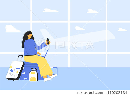 Woman sitting on the suitcase at the airport and working with laptop and phone waiting for a flight. Woman sitting on the suitcase at the airport and working with laptop and phone waiting for a flight. 110202184