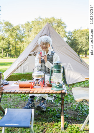 Senior woman enjoying camping 110202554