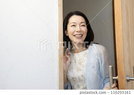 一個女人打開門微笑 一個女人打開門微笑 110203161