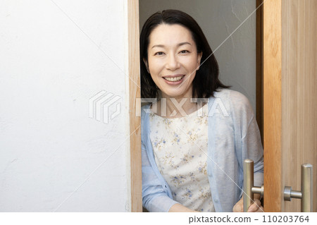 一個女人打開門微笑 一個女人打開門微笑 110203764