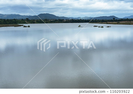 Reflection of clouds on lake surrounded by mountains. 110203922
