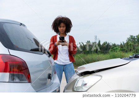 Half Thai African driver check for damage after a car accident before taking pictures and sending insurance. Online car accident insurance claim after submitting photos and evidence to an insurance. 110204779