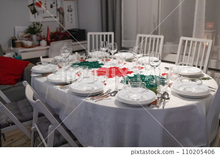 Christmas and New Year 2024. Beautiful table setting with Christmas serving decorations in living room 110205406