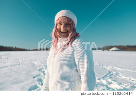 Young Caucasian Beautiful pink hair woman smile at camera taking selfie photo or video call in winter snow forest  110205414