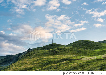 Wooden cross on top of mountain and bright sky in Swiss Alps at Switzerland Wooden cross on top of mountain and bright sky in Swiss Alps at Switzerland 110206136
