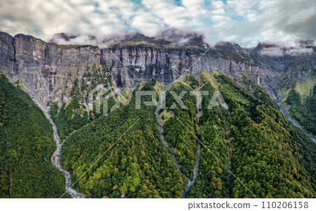 Giffre valley of mountain range with cascade and foggy in French Alps at Sixt Fer a Cheval, France Giffre valley of mountain range with cascade and foggy in French Alps at Sixt Fer a Cheval, France 110206158