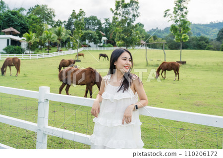 Beautiful asian woman relaxing in horse farm Beautiful asian woman relaxing in horse farm 110206172