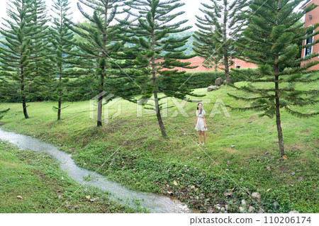 Beautiful asian woman standing and relaxing in the garden on vacation Beautiful asian woman standing and relaxing in the garden on vacation 110206174