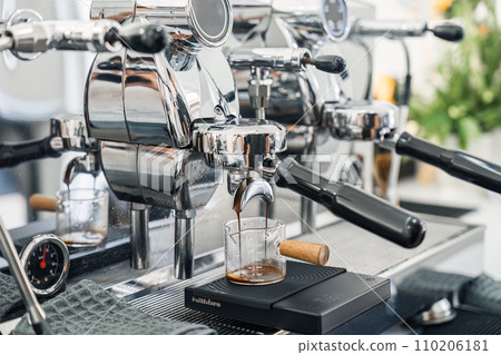 Espresso machine making hot coffee into dosing cup in coffee shop Espresso machine making hot coffee into dosing cup in coffee shop 110206181