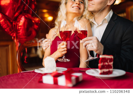 Young couple having a romantic dinner and toasting with glass of red wine. Surprise and love concept 110206348