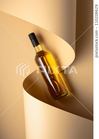 Bottle of white wine on a beige background. 110206629