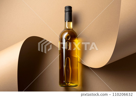 Bottle of white wine on a beige background. 110206632