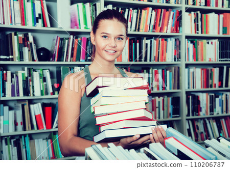 The brunette chose a lot of books in the university library 110206787