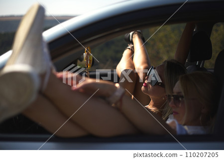 skinny girls eat in the car away from the bustle of the city, best friends are free and enjoy the journey. High quality photo 110207205