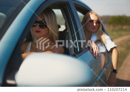 skinny girls eat in the car away from the bustle of the city, best friends are free and enjoy the journey. High quality photo 110207214
