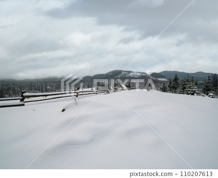Countryside hills, groves and farmlands in winter remote alpine mountain village 110207613