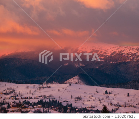 Winter red sunset alpine top  view from mountain village. Picturesque seasonal, nature and countryside beauty concept scene. 110207623