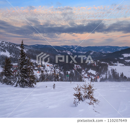 Picturesque winter windy and cloudy morning alps. View of famous Ukrainian Dragobrat ski resort from Svydovets mountain ridge. Picturesque winter windy and cloudy morning alps. View of famous Ukrainian Dragobrat ski resort from Svydovets mountain ridge. 110207649