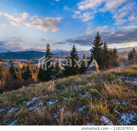 Late autumn mountain pre sunset scene with snow covered tops in far. Picturesque traveling, seasonal, nature and countryside beauty concept scene. Carpathians, Ukraine. Late autumn mountain pre sunset scene with snow covered tops in far. Picturesque traveling, seasonal, nature and countryside beauty concept scene. Carpathians, Ukraine. 110207652