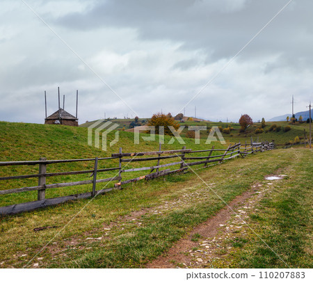 Hazy and overcast autumn Carpathian Mountains and dirty countryside path, Ukraine. 110207883