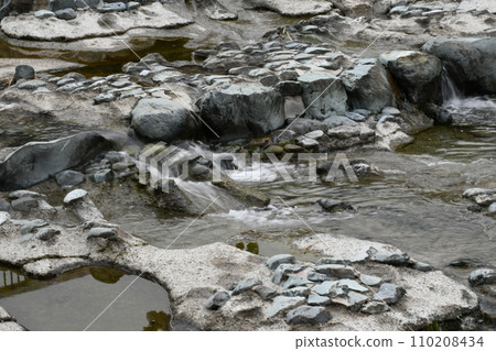Clear stream flowing between rocks 110208434