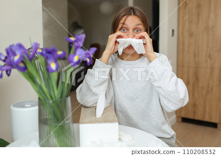 Allergy, flu, cold, rhinitis. Funny face of sick woman with paper tissues inside nose from runny nose and sneezes at home. Hay fever, sinusitis and female with viral infection blowing in handkerchief Allergy, flu, cold, rhinitis. Funny face of sick woman with paper tissues inside nose from runny nose and sneezes at home. Hay fever, sinusitis and female with viral infection blowing in handkerchief 110208532