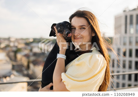 Female standing and holding pet close to face outside Female standing and holding pet close to face outside 110208949
